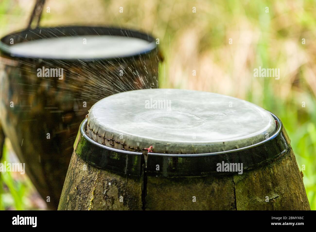 Eine Sammlung von Trommeln schlagen mit Hilfe eines computergesteuerten Bewässerungssystems, das einen Rhythmus von Wassertropfen auf die Trommeln auslöst Stockfoto
