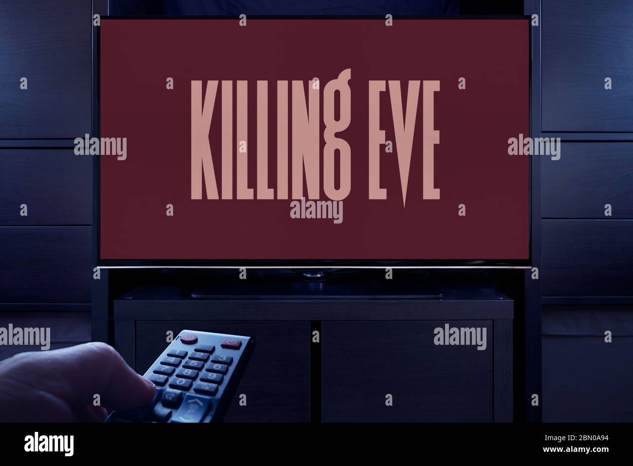 Ein Mann zeigt eine Fernbedienung auf den Fernseher, der den Hauptbildschirm des Tötungsabends anzeigt (nur für redaktionelle Zwecke). Stockfoto