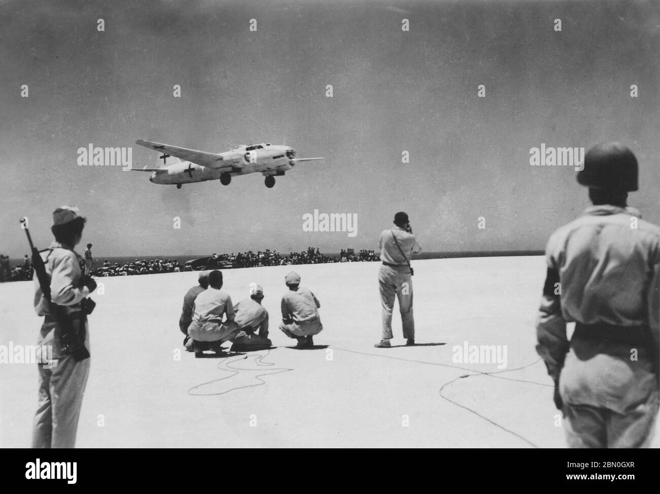 [ 1945 Japan - Japanische Kapitulation WWII ] - EIN speziell markierter japanischer Mitsubishi G4M 'Betty' Bomber landet auf der US-Insel Iejima in der Präfektur Okinawa kurz nach Mittag am 19. August 1945 (Showa 20). Das Flugzeug führte japanische Abgesandte auf dem Weg nach Manila, um sich mit den Mitarbeitern von General Douglas MacArthur zu treffen, um die Einzelheiten der Kapitulation Japans zum Ende des Zweiten Weltkriegs zu erarbeiten. Silberdruck mit Gelatine aus dem 20. Jahrhundert. Stockfoto