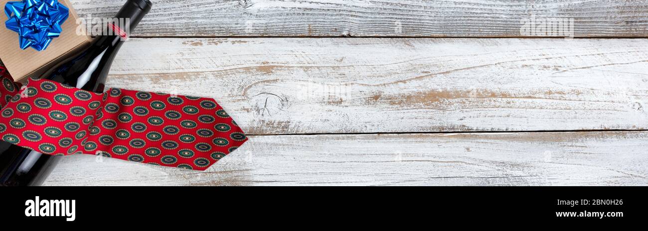 geschenkbox zum Happy Fathers Day mit einer Krawatte und einer Flasche Rotwein auf rustikalem Holz. Stockfoto