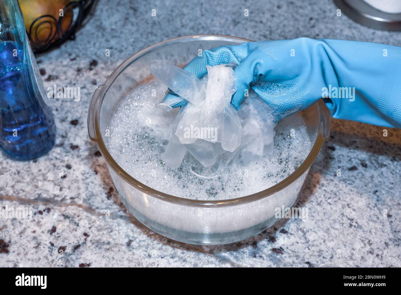 Waschen von Einweghandschuhen zur Wiederverwendung während der Covid-19-Pandemie. Stockfoto