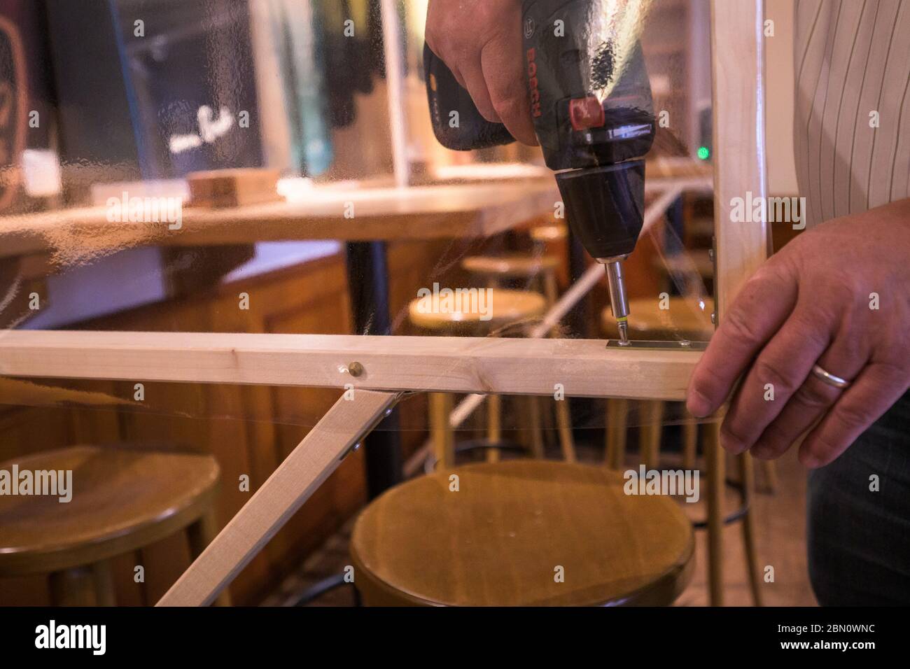 Mainz, Deutschland. Mai 2020. Burkhard Geibel-Emden, Pächter der traditionellen Kneipe zur Andau, installiert einen Spitting-Schutz im Raucherbereich. Die Taverne im Stadtzentrum will unter Einhaltung der Corona Hygienevorschriften wieder eröffnet werden. Die Landesregierung in Rheinland-Pfalz hat zum 13. Mai grünes Licht für das Restaurant gegeben. Quelle: Andreas Arnold/dpa/Alamy Live News Stockfoto