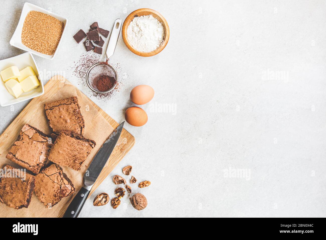 Draufsicht der frisch gebackenen hausgemachten Brownie Kuchen mit Rezeptur Zutaten auf weißem rustikalen Hintergrund angeordnet. Kopierbereich. Stockfoto