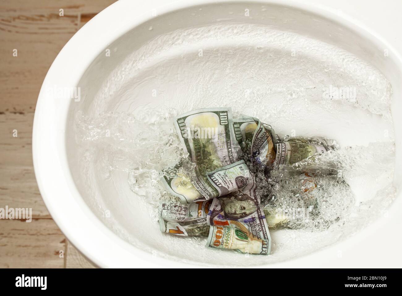 Verlust von Geld. Schlechte Investition oder Investition. Geldmittel werden in die Toilette gespült. Stockfoto