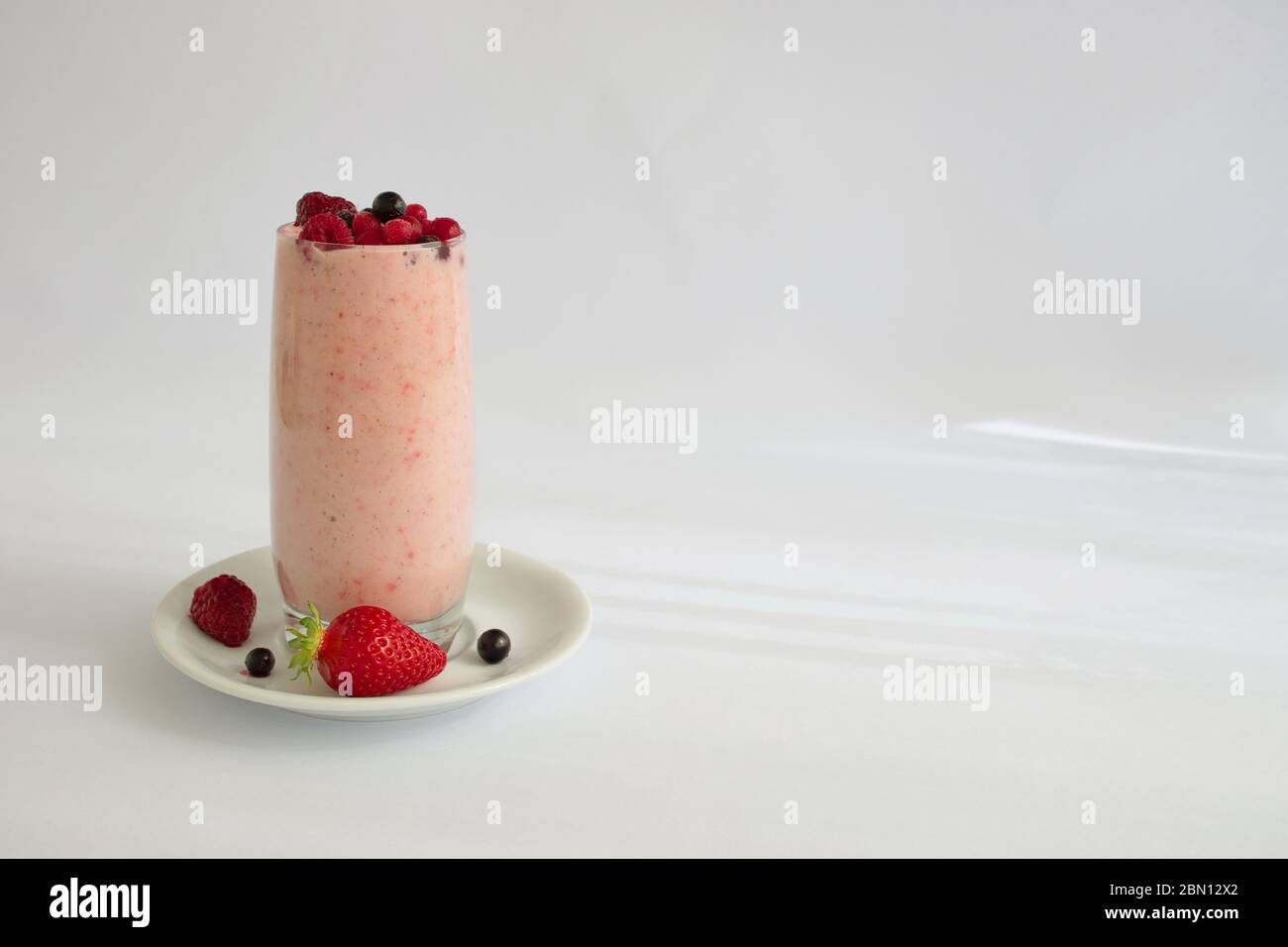 Farbenfroher Smoothie im Glas mit frischen Früchten auf weißem Hintergrund Stockfoto
