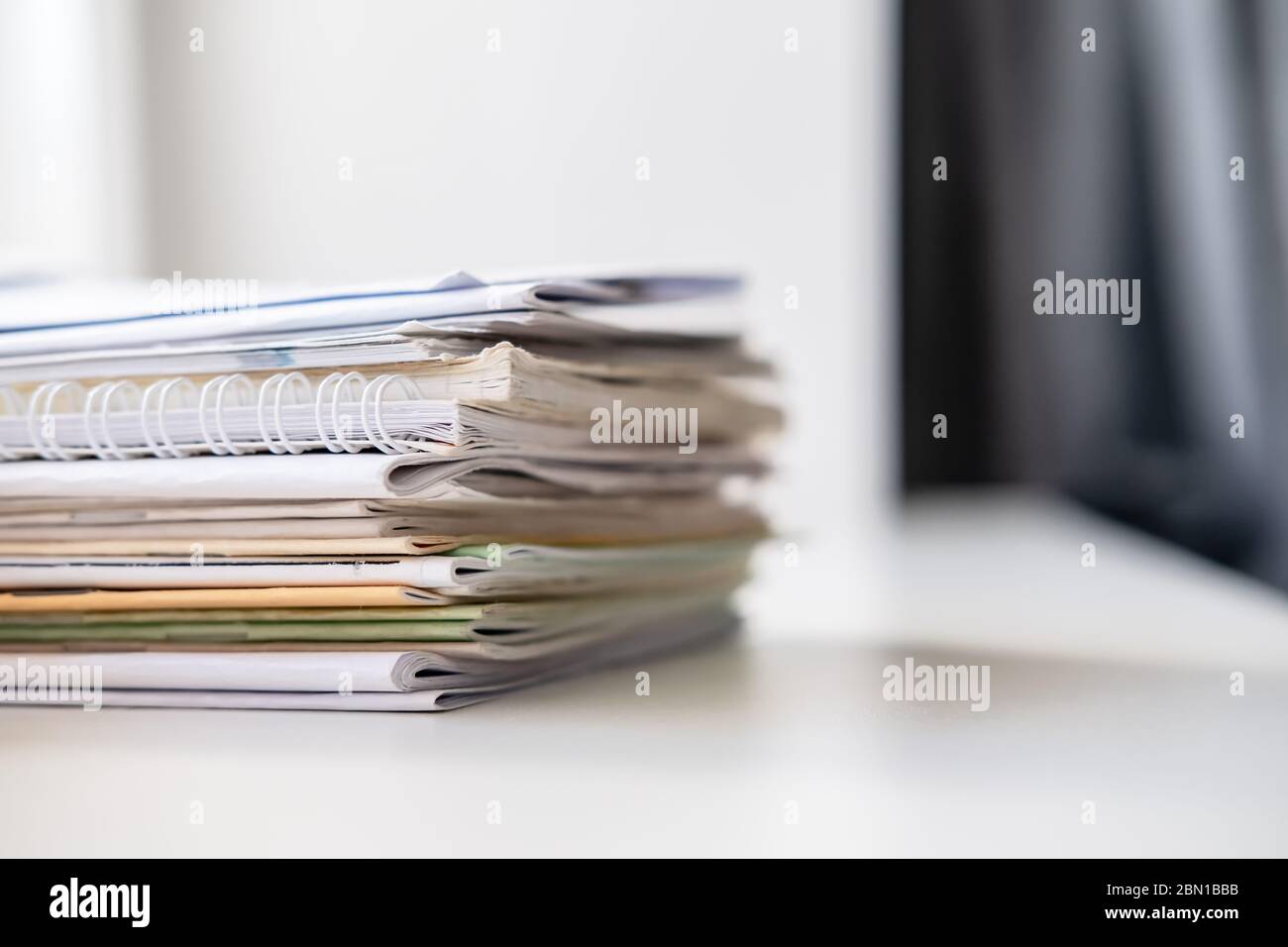 Stapel verschiedener Notizbücher auf der weißen Fensterbank, im natürlichen Licht vom Fenster. Stockfoto