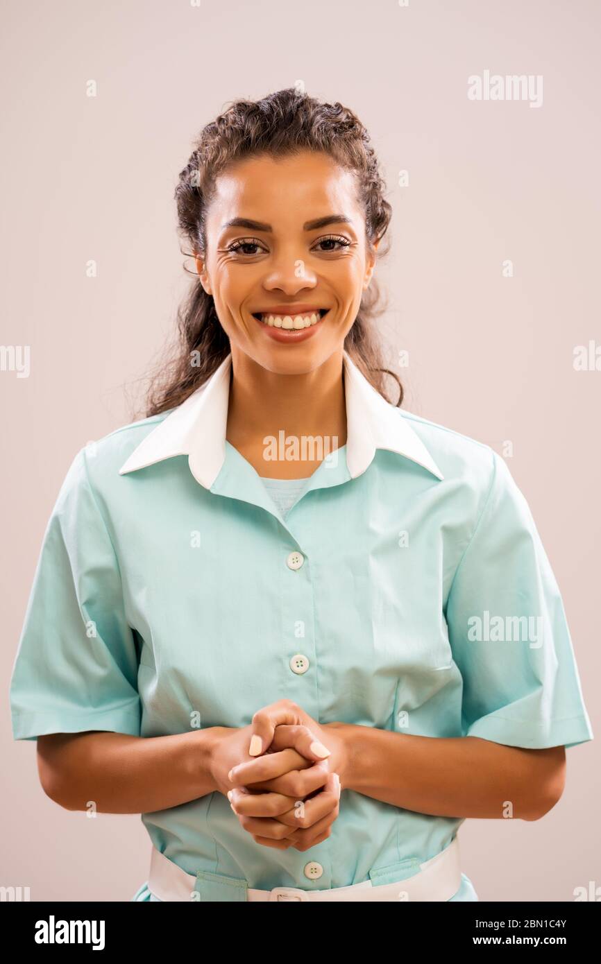 Porträt der jungen glücklichen Krankenschwester, die Kamera anschaut und lächelt. Stockfoto