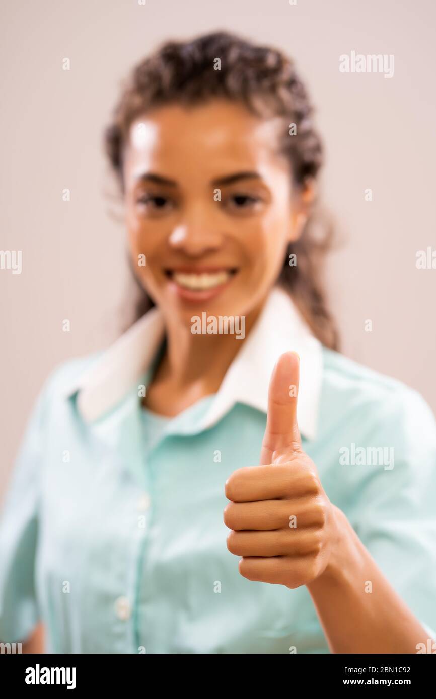 Porträt der jungen glücklichen Krankenschwester, die Kamera anschaut und lächelt. Stockfoto