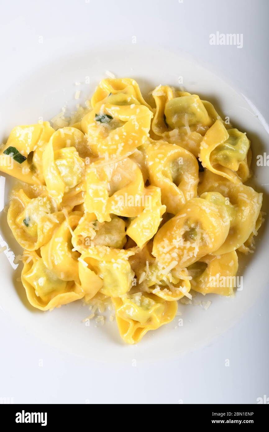 Tortellini mit Ricotta-Käse und Spinat, Butter, Salbei-Sauce, geriebenem Parmesan. Parmigiano-Reggiano Flocken über traditionelle italienische Pasta gekocht, ser Stockfoto