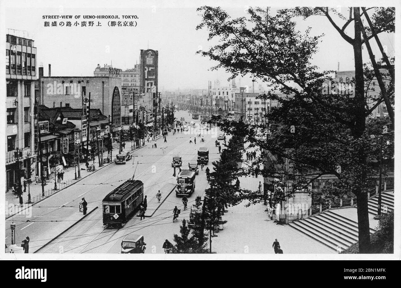 [ 1930er Jahre Japan - Straßenansicht von Ueno Hirokoji, Tokyo ] - Straßenbahnen, Busse und Autos in Ueno Hirokoji in Tokio. Auf der rechten Seite befindet sich der Eingang zum Ueno Park. Vintage-Postkarte des 20. Jahrhunderts. Stockfoto