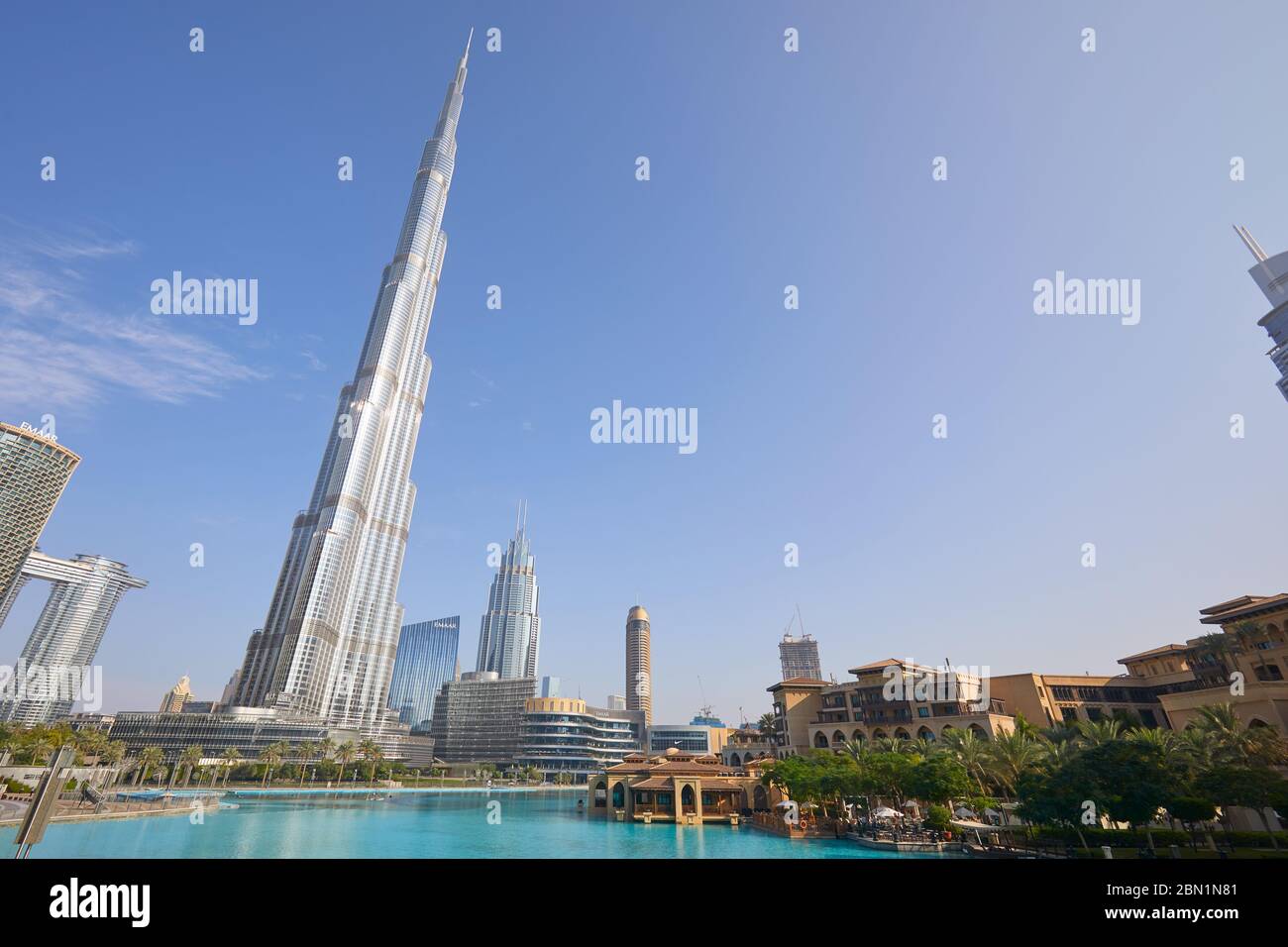 DUBAI, VEREINIGTE ARABISCHE EMIRATE - 19. NOVEMBER 2019: Burj Khalifa Wolkenkratzer, Souk al Bahar und künstlicher See an einem sonnigen Tag, niedrige Winkelansicht Stockfoto