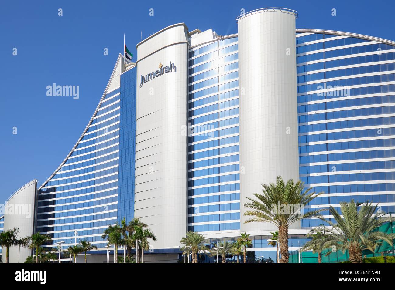 DUBAI, VEREINIGTE ARABISCHE EMIRATE - 22. NOVEMBER 2019: Jumeirah Beach Luxushotel an einem sonnigen Tag mit Palmen, blauer Himmel in Dubai Stockfoto