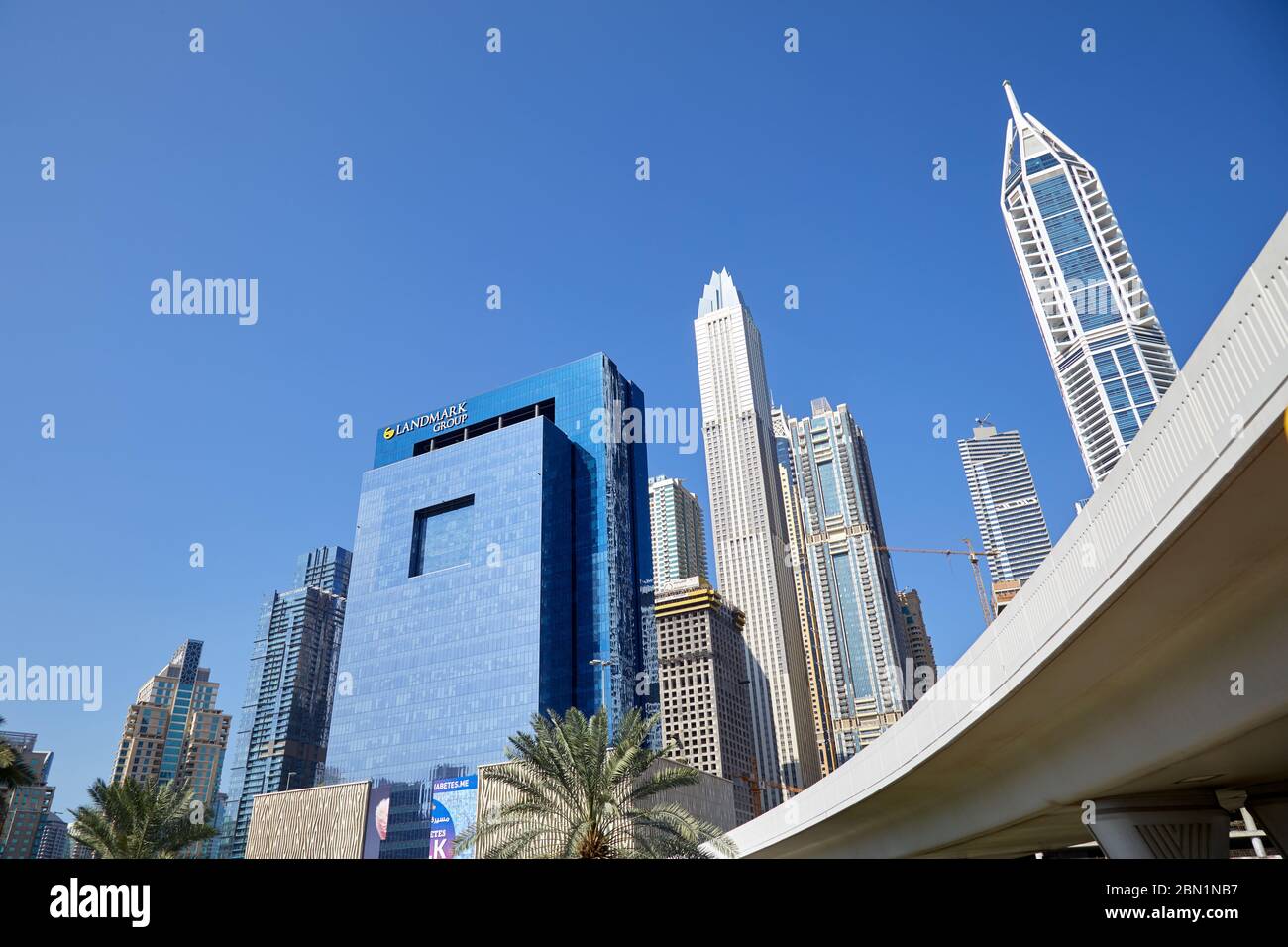 DUBAI, VEREINIGTE ARABISCHE EMIRATE - 22. NOVEMBER 2019: Moderne Wolkenkratzer und Überflug in der Innenstadt von Dubai an einem sonnigen Tag, klaren blauen Himmel Stockfoto