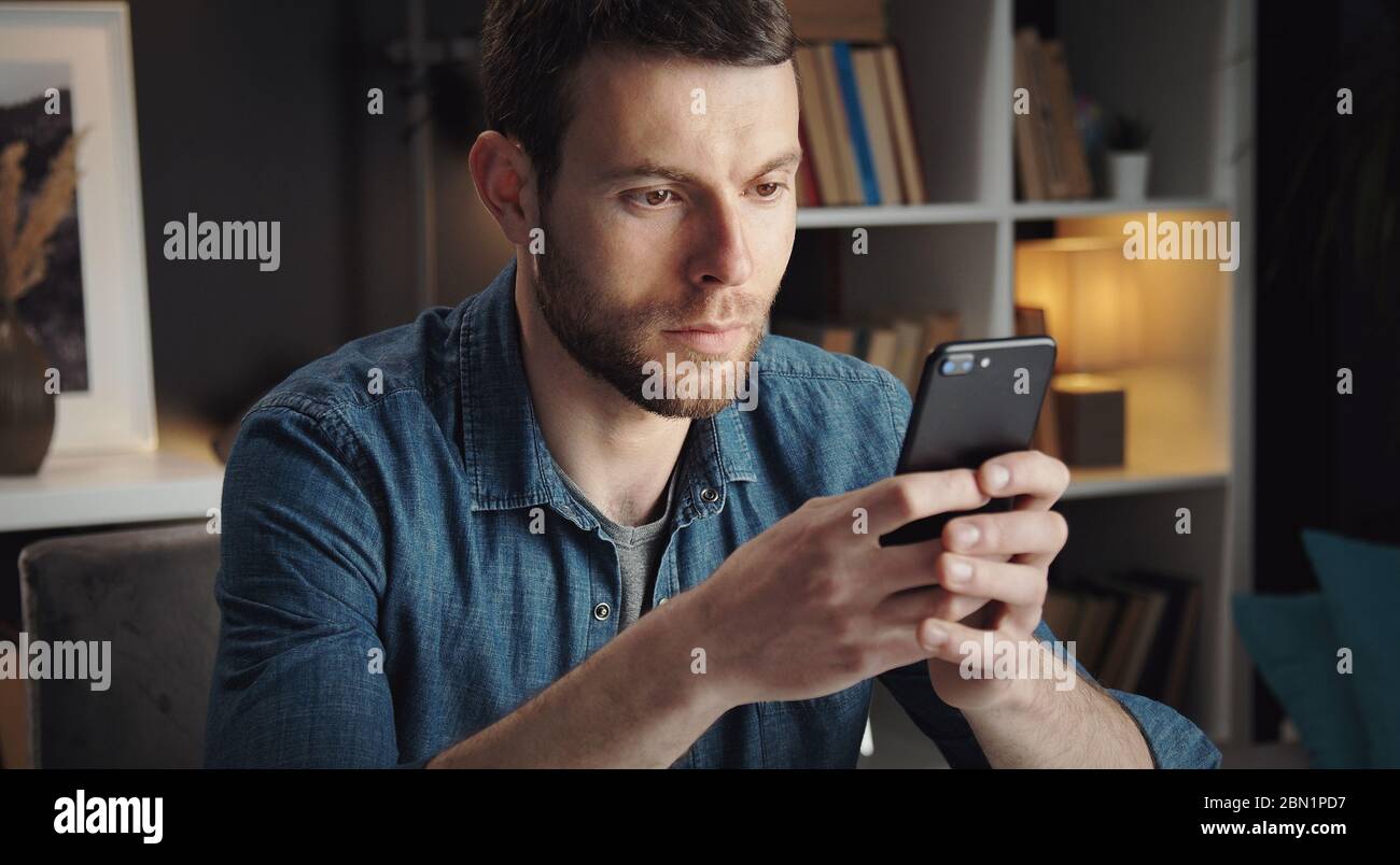 Junger Mann suchen Smartphone-Bildschirm Stockfoto