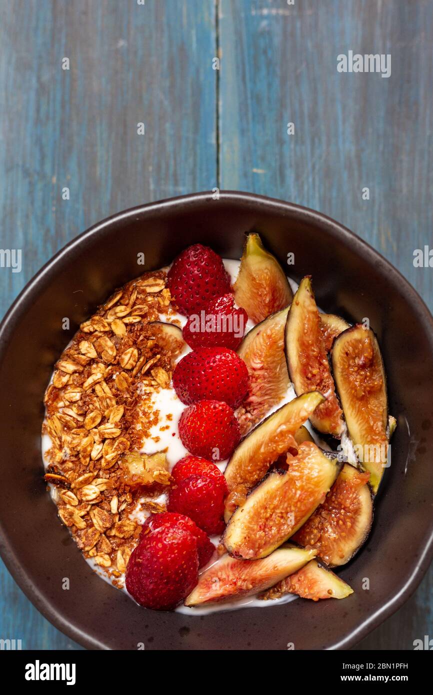 Gericht mit Joghurt, Erdbeeren, Müsli, Nüssen, ideal für eine energiegeladene vegetarische Ernährung Stockfoto