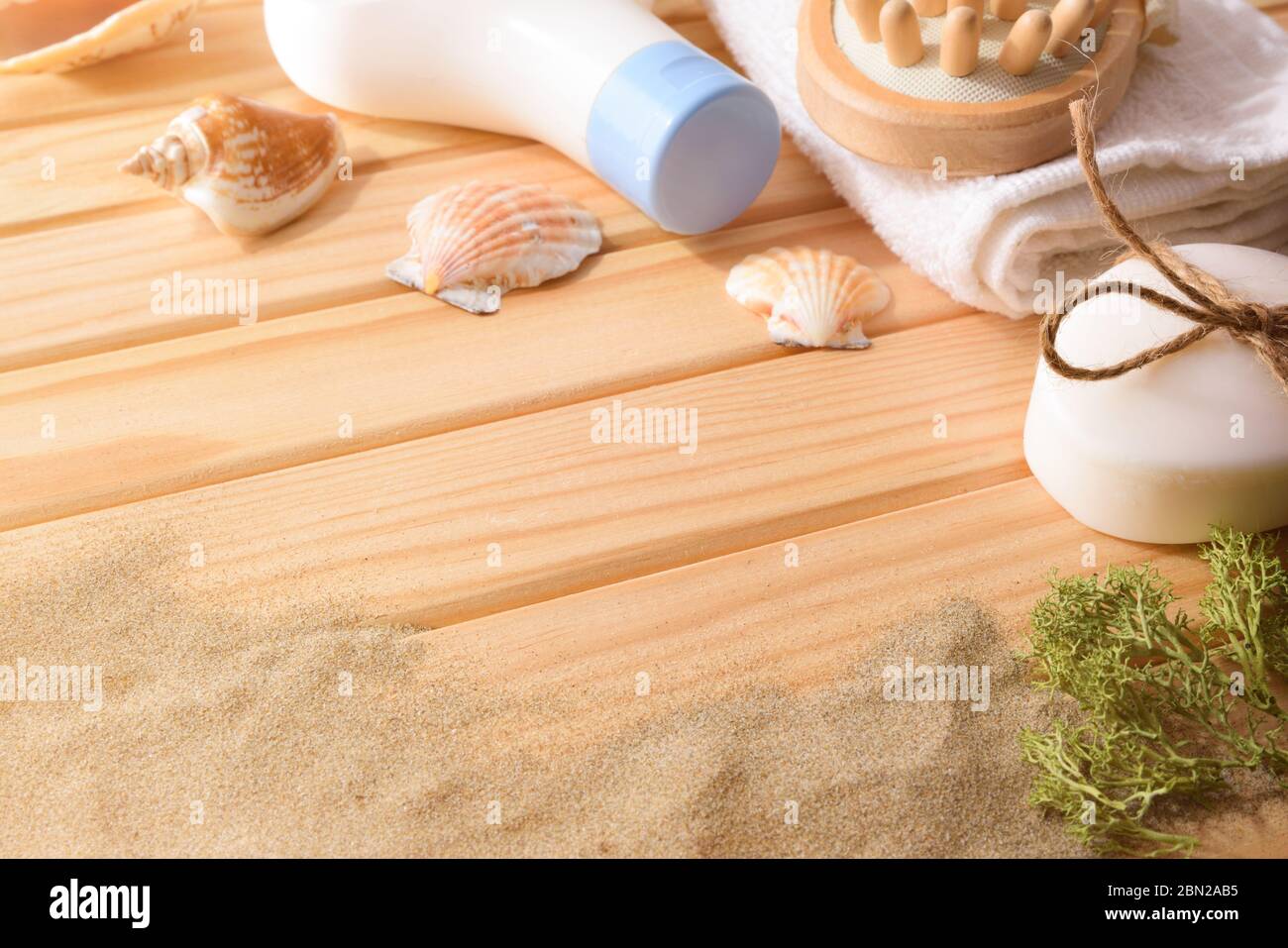 Thalassotherapie-Produkte für die Körperbehandlung auf Holzlatten Tisch mit Algen Muscheln und Sand verziert. Höhenansicht. Horizontale Zusammensetzung. Stockfoto