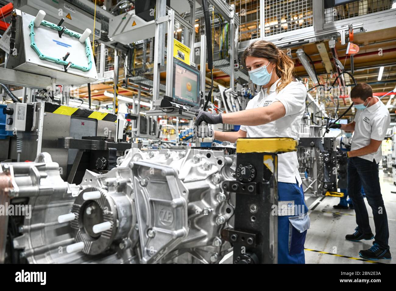 Friedrichshafen, Deutschland. Mai 2020. Im zweiten Werk des Automobilzulieferers ZF Friedrichshafen arbeitet Mechaniker Vanessa an einem Getriebe für Lkw namens ZF Traxon. ZF Friedrichshafen nimmt langsam den Betrieb mit Schutz- und Hygienemaßnahmen wieder auf. Jeder Arbeiter trägt einen Mund- und Nasenschutz, Mindestabstände sind auf dem Boden markiert und einige Arbeitsplätze sind durch Plexiglasscheiben getrennt. Quelle: Felix Kästle/dpa/Alamy Live News Stockfoto