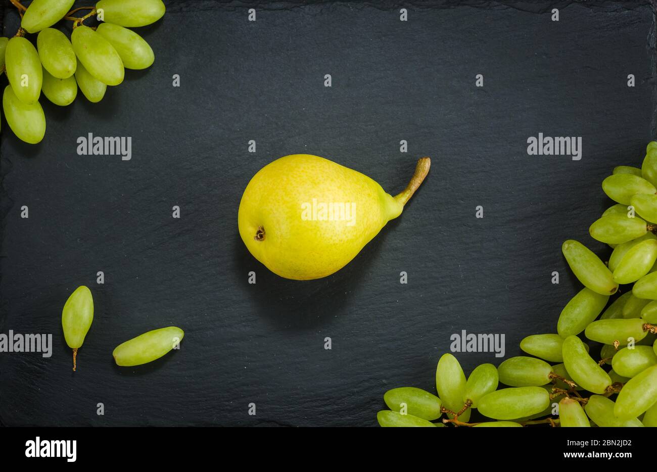 Birne Trauben auf einem dunklen Stein Hintergrund vegatarian Gesundheit Obst Gemüse dunklen Stein Hintergrund Stockfoto