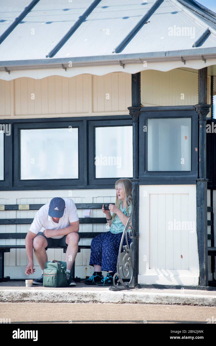 Ein Pärchen picknicken in einem Schutzhaus am Meer in Paignton, Großbritannien Stockfoto