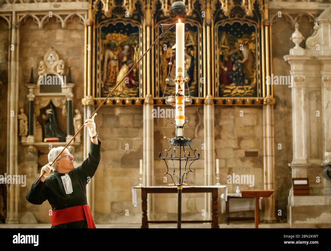 Canon Maggie McLean, Canon Missioner in York Minster, entzündet die Paschal Candle als Klerus in der Kathedrale eine neue Initiative gestartet, um die Kerze als Fokus für das Gebet für alle von der Coronavirus-Pandemie betroffen. Stockfoto