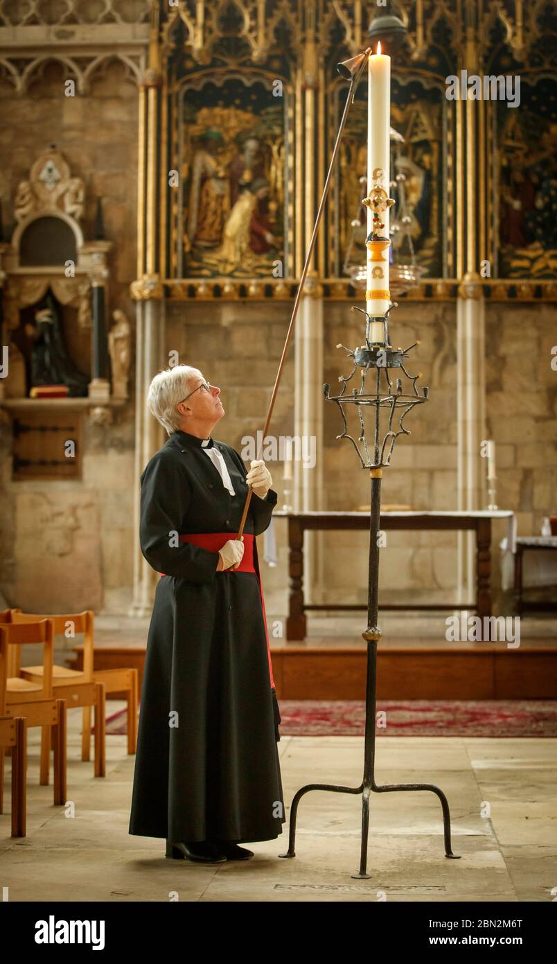 Canon Maggie McLean, Canon Missioner in York Minster, entzündet die Paschal Candle als Klerus in der Kathedrale eine neue Initiative gestartet, um die Kerze als Fokus für das Gebet für alle von der Coronavirus-Pandemie betroffen. Stockfoto