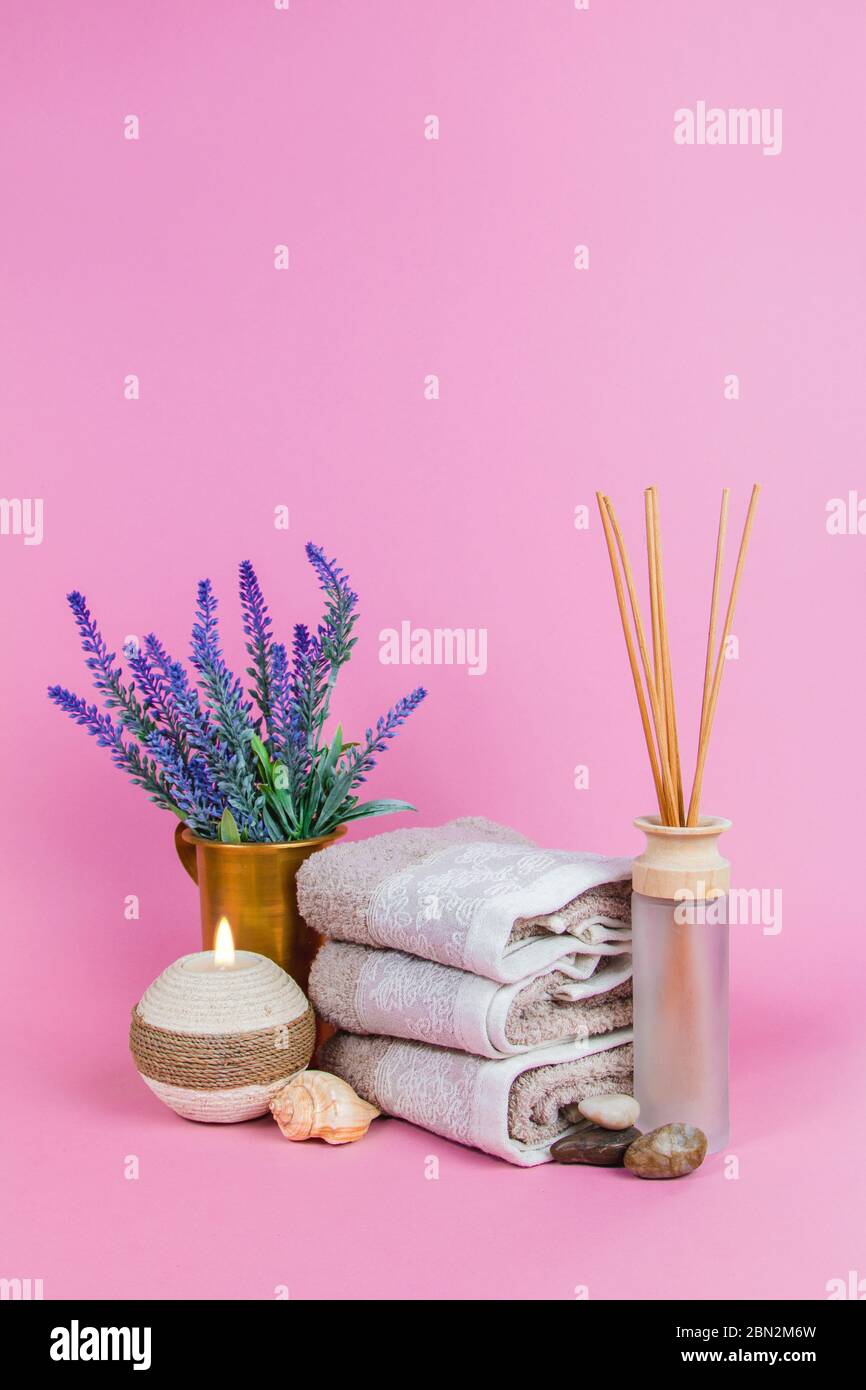 Spa Essentials, Duftstäbchen, Steine, Handtücher, Muschel auf rosa Hintergrund Stockfoto