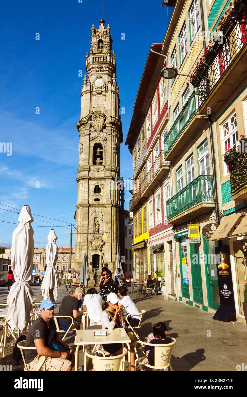Porto, Portugal : die Leute sitzen in einem Café im Freien neben dem barocken Torre dos Clérigos Turm der Igreja dos Clérigos Kirche von italienischem Architekten Stockfoto