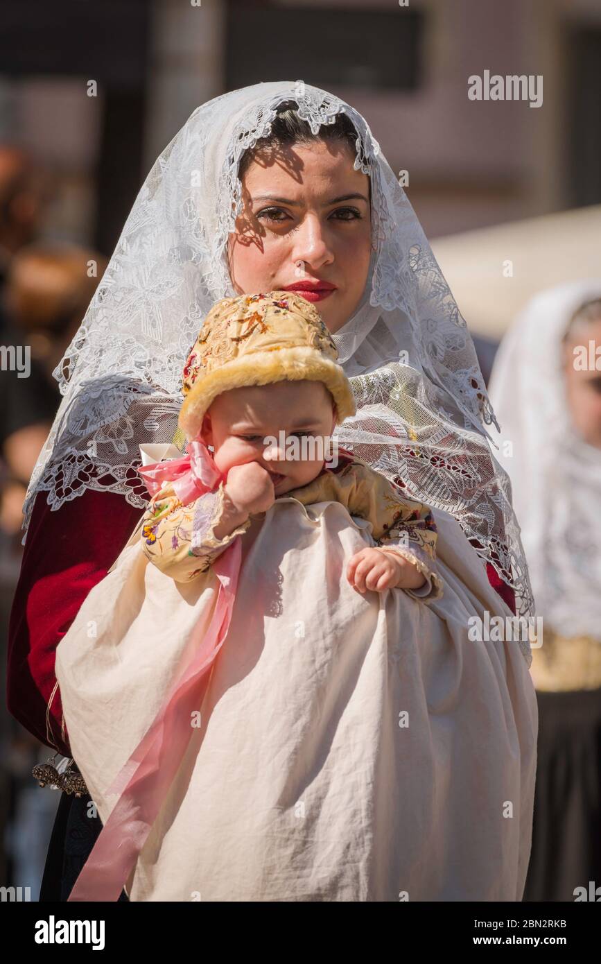 Mutter Kind, Porträt einer Frau und ihres Babys in traditioneller Tracht in der großen Parade des Cavalcata Volksfestes in Sassari, Sardinien gekleidet. Stockfoto