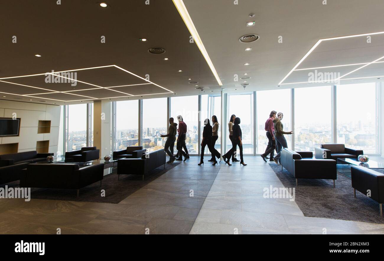 Geschäftsleute, die in der modernen Bürolobby zu Fuß gehen Stockfoto