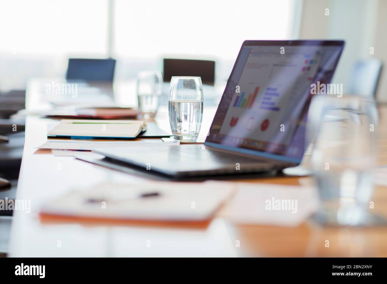 Laptop und Papierkram auf dem Tisch des Konferenzraums Stockfoto