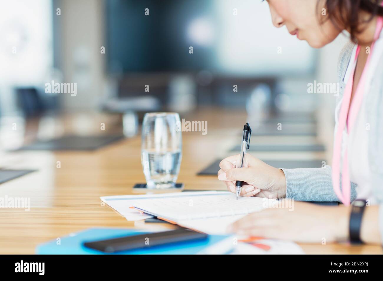 Engagierte Geschäftsfrau mit Schreibarbeit im Konferenzraum Stockfoto