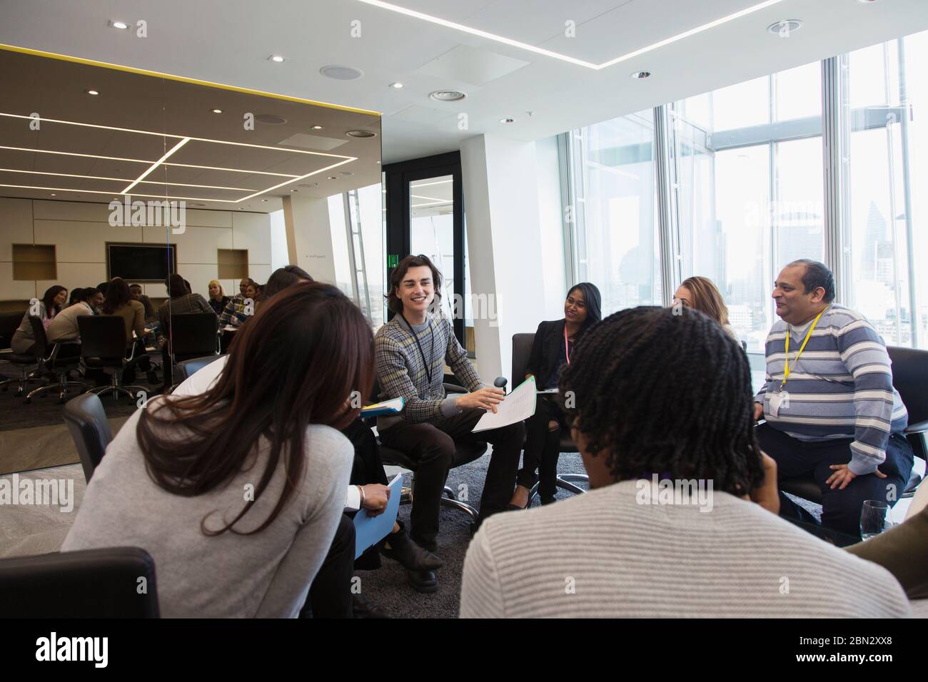 Geschäftsleute diskutieren Papiere im Kreis in der Sitzung Stockfoto