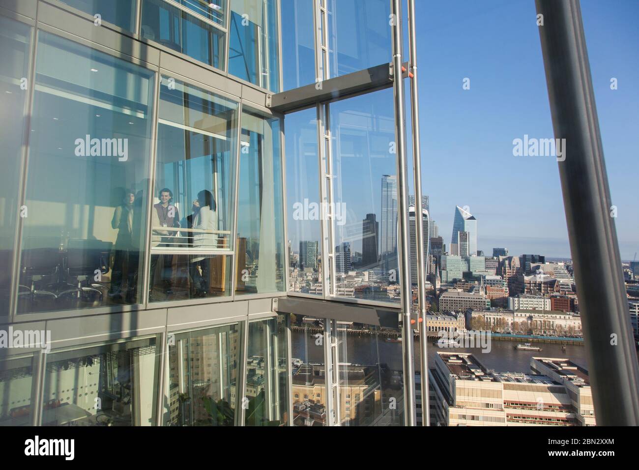 Geschäftsleute sprechen am sonnigen städtischen Hochhaus Bürofenster Stockfoto