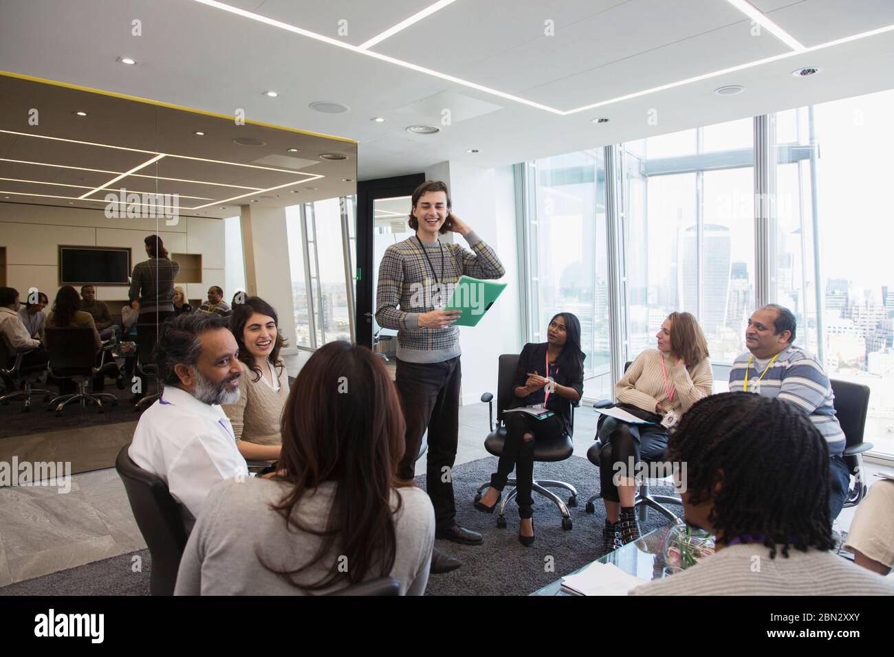 Lächelnder Geschäftsmann führt Meeting im Büro Stockfoto