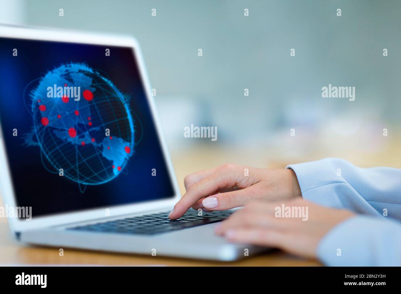 Wissenschaftlerin mit Blick auf globale Pandemieausbrüche auf dem Laptop Stockfoto