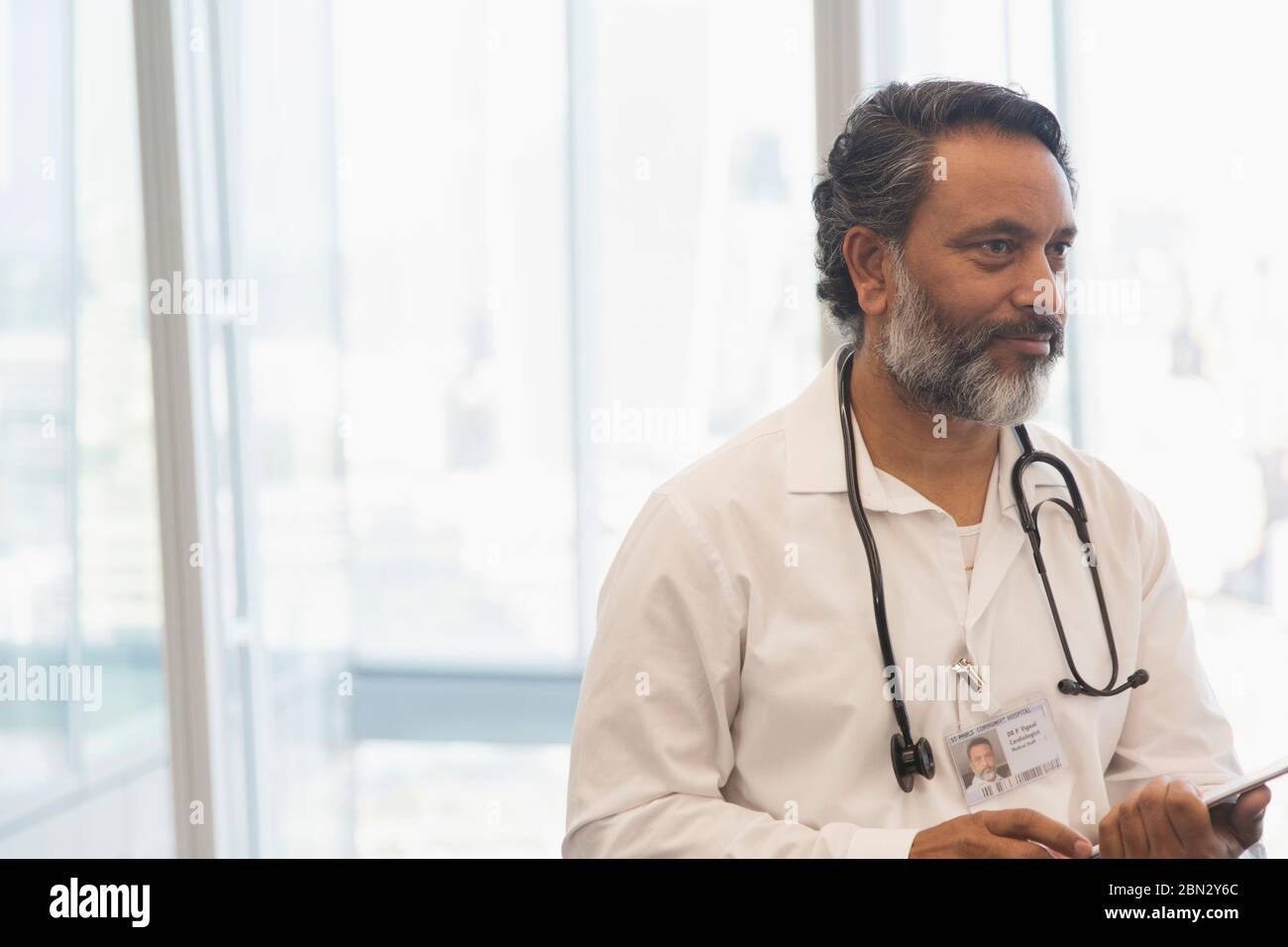 Männlicher Arzt mit Stethoskop im Büro Stockfoto