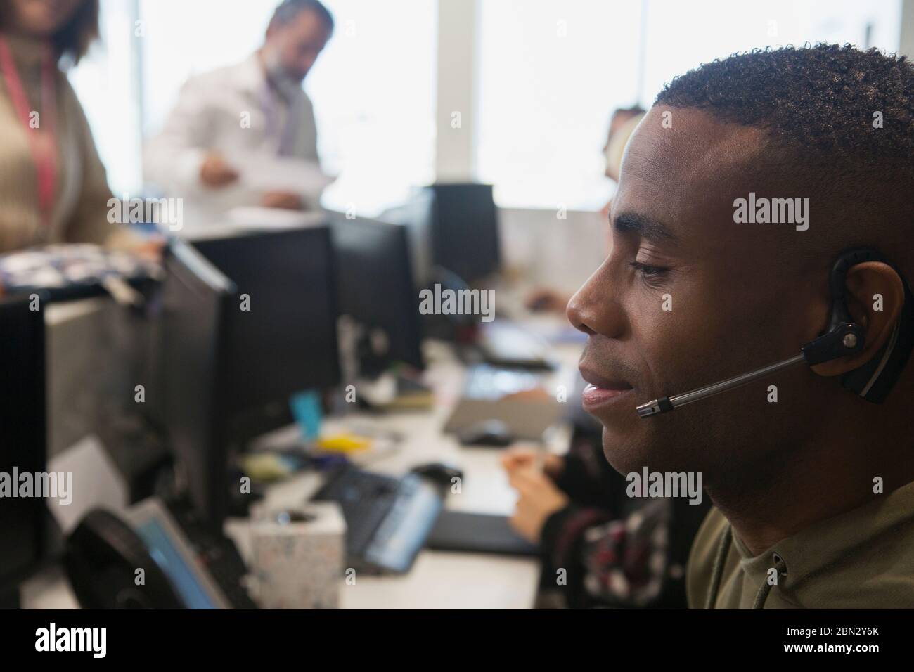 Geschäftsmann mit Headset im Büro Stockfoto