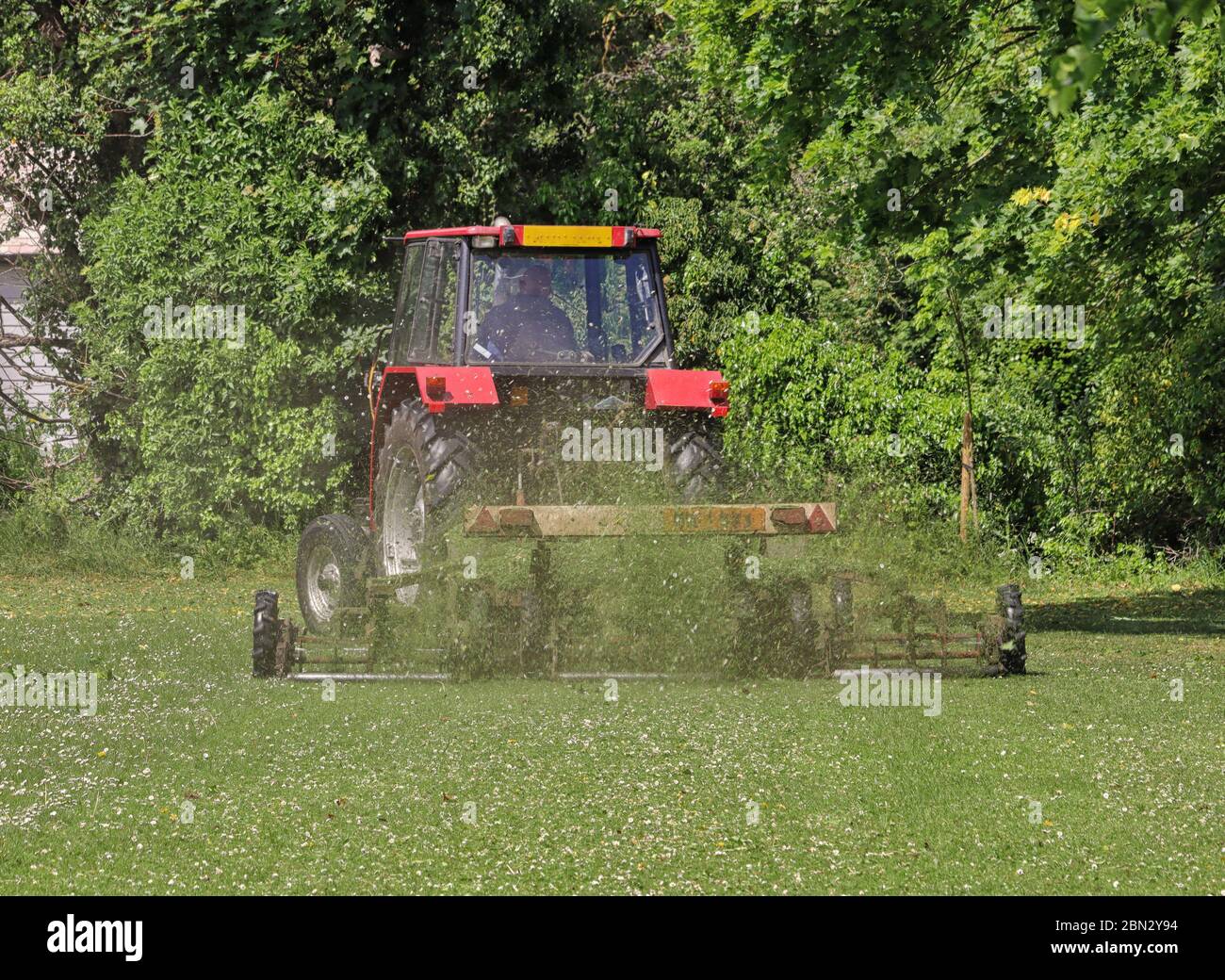 Traktor mit Anhänger Rasenmähen in einem öffentlichen Park in England Stockfoto