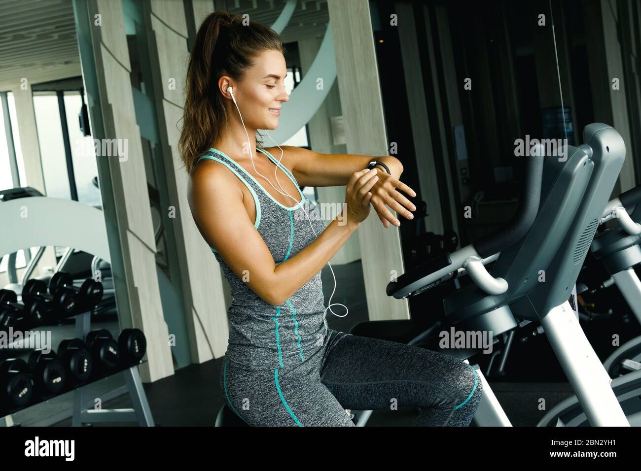 Frau ist mit Smart Watch während ihres Trainings im Fitnessstudio Stockfoto