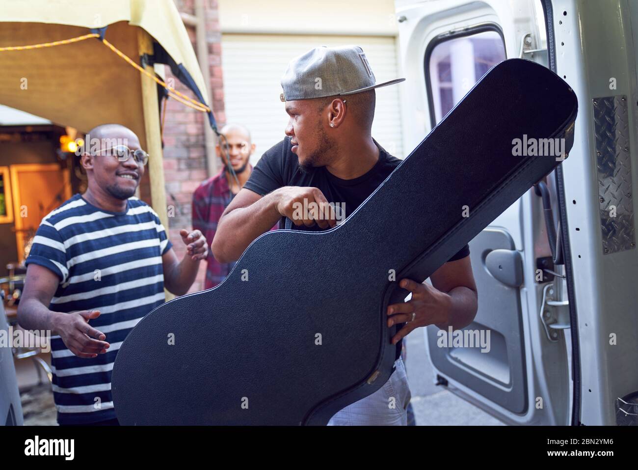 Musiker laden Gitarrenkoffer in den Van Stockfoto