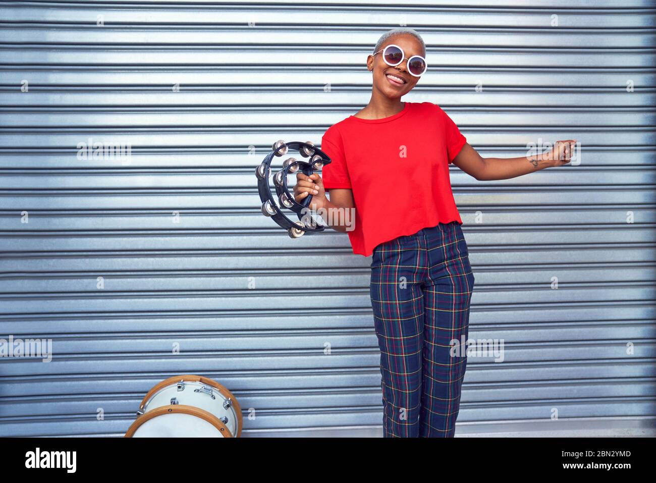 Portrait glückliche junge Musikerin mit Tamburin Stockfoto