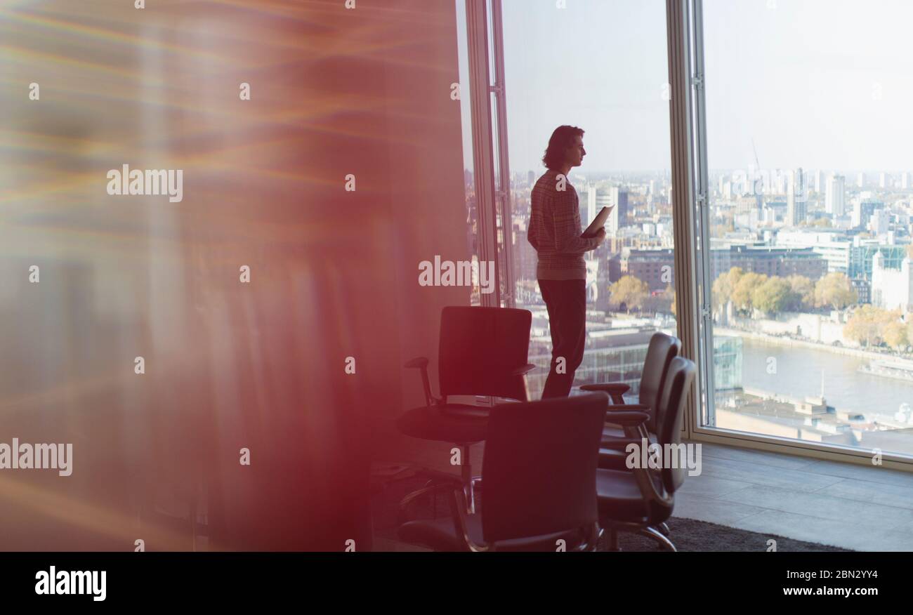Nachdenklicher Geschäftsmann steht am Hochhaus Bürofenster Stockfoto
