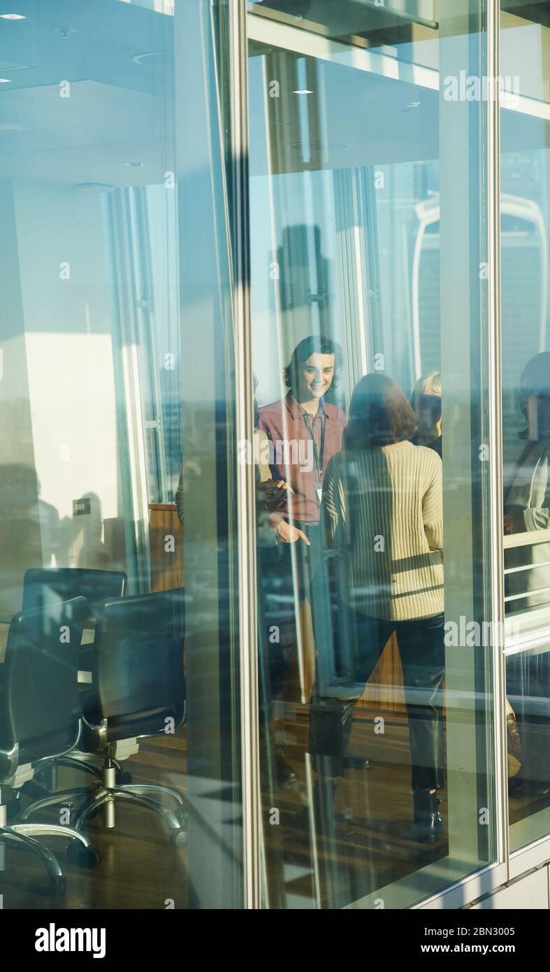 Geschäftsleute sprechen im sonnigen Bürofenster Stockfoto