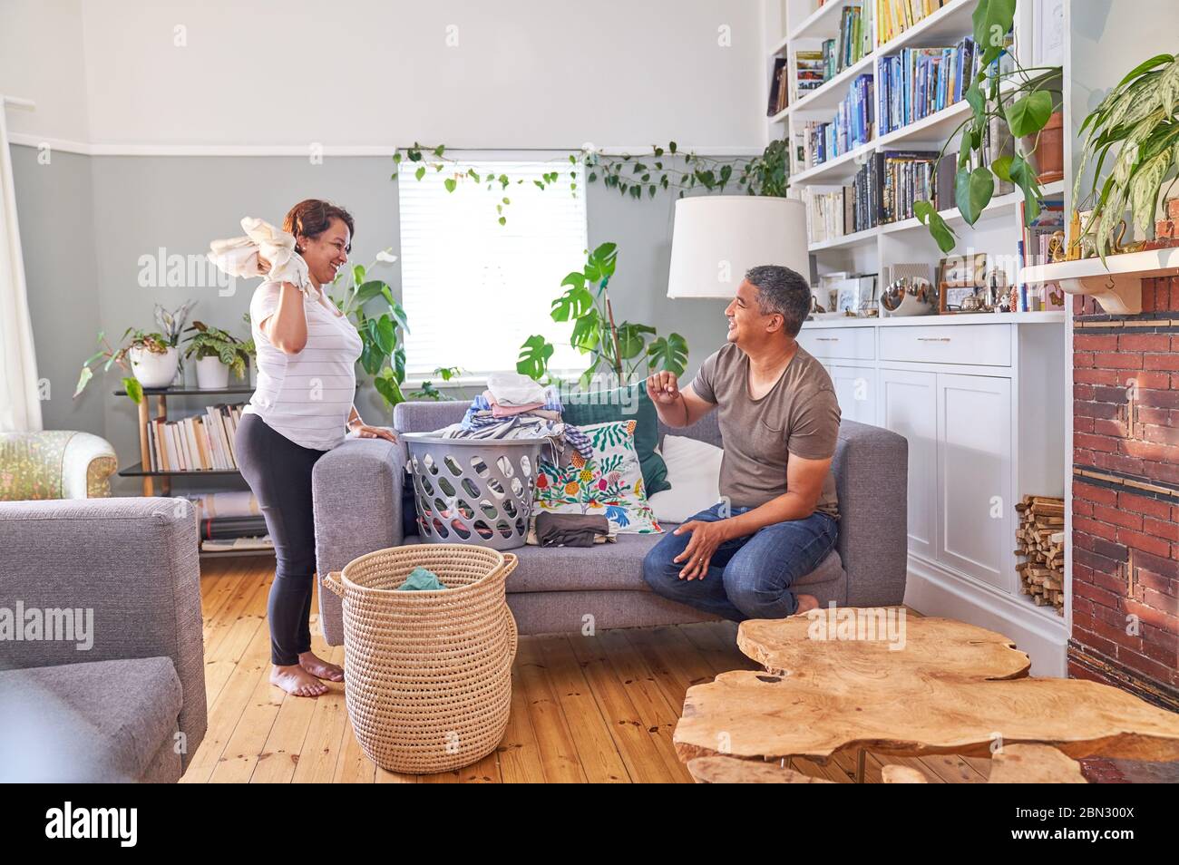 Verspielt ältere paar Falten Wäsche im Wohnzimmer Stockfoto