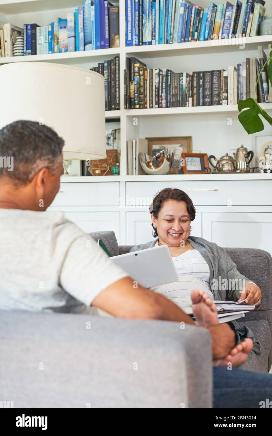 Reifes Paar mit digitalem Tablet auf dem Sofa im Wohnzimmer Stockfoto