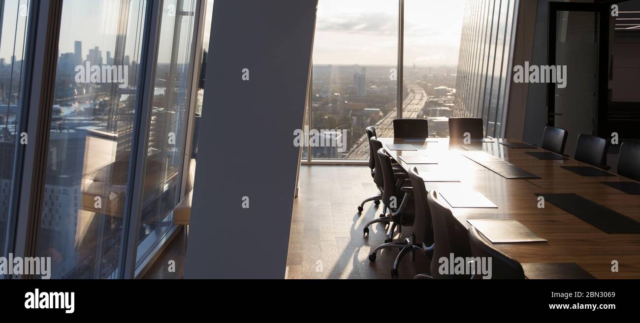 Sonniger, leerer, moderner Konferenzraum mit Blick auf die Stadt Stockfoto