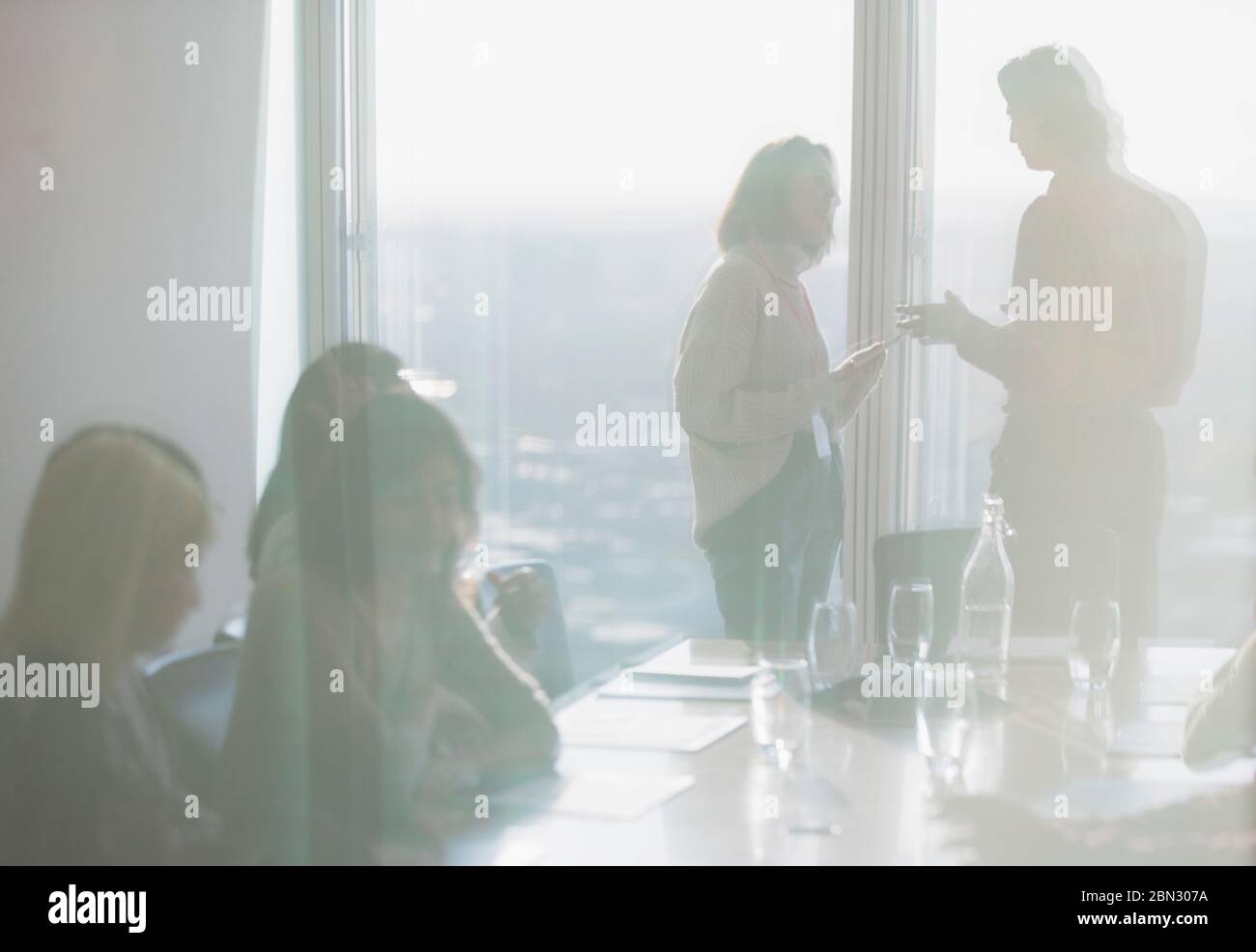 Geschäftsleute sprechen in sonnigen Konferenzräumen Stockfoto