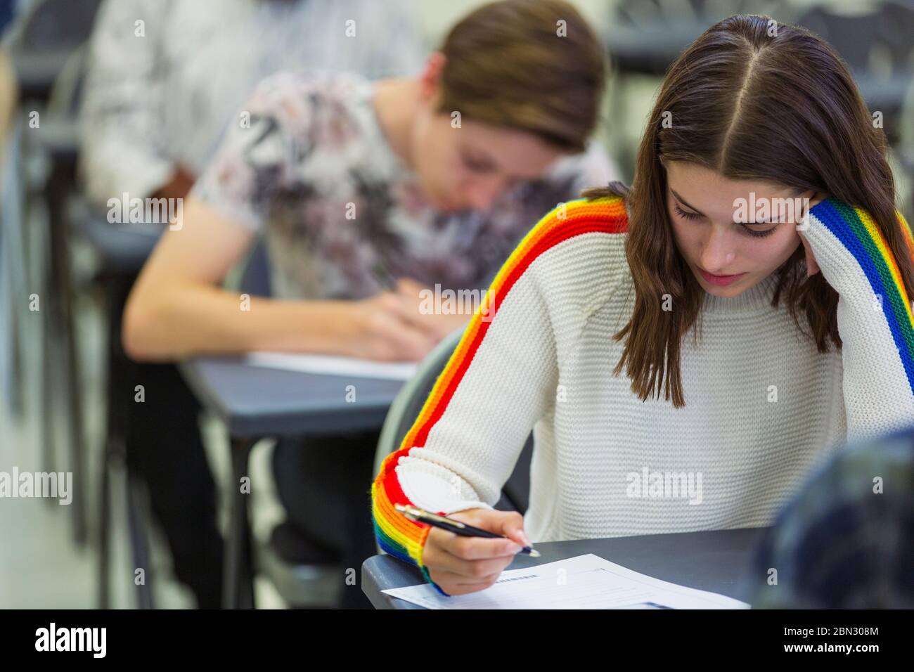 Fokussierte High School Mädchen Schüler, die Prüfung am Schreibtisch im Klassenzimmer Stockfoto