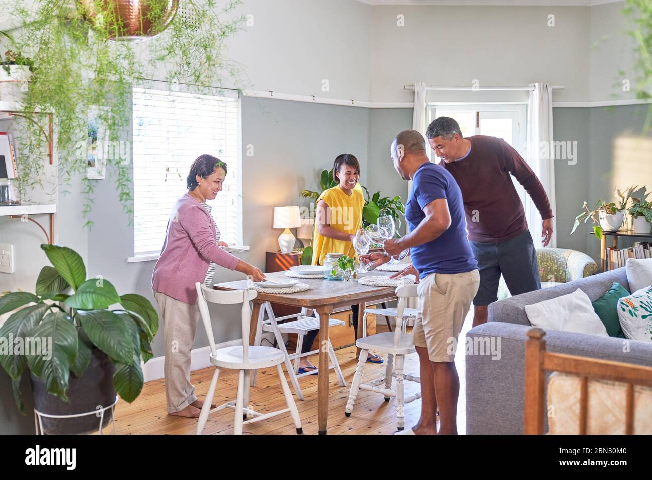 Ältere Freunde, die einen Esstisch für das Mittagessen einrichten Stockfoto