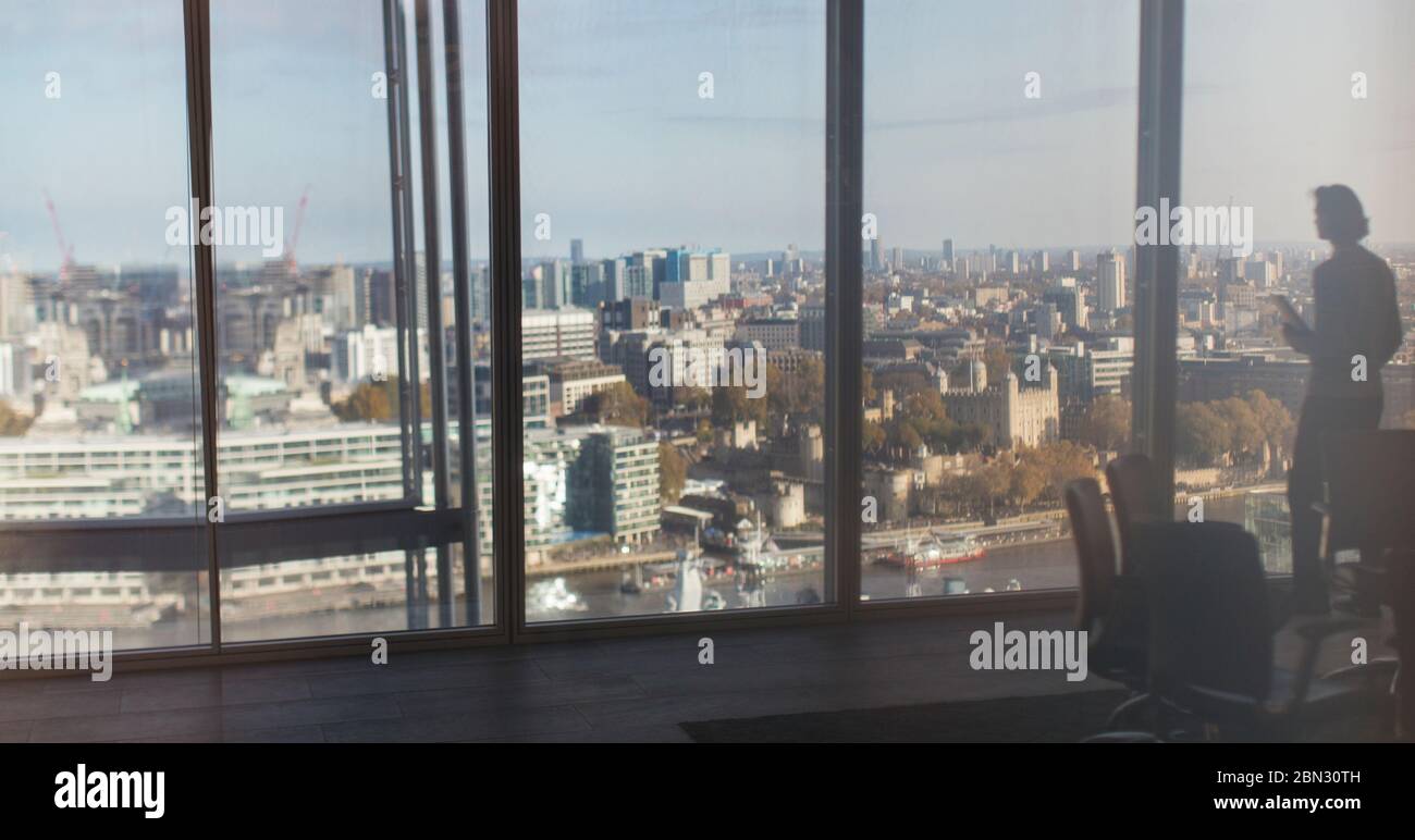Silhouette Businessman im Hochhausfenster mit Blick auf die Stadt, London, Großbritannien Stockfoto